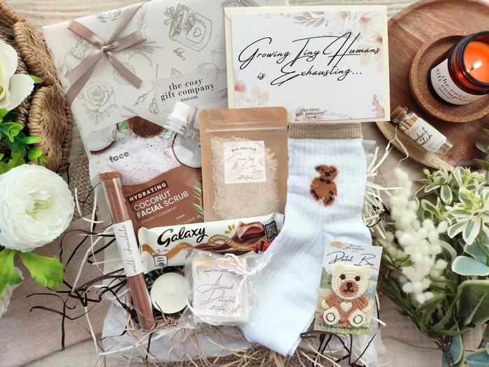 Gift Wrapped Box with various items including a bath salts, soap, and face scrub on a decorative surface with flowers.