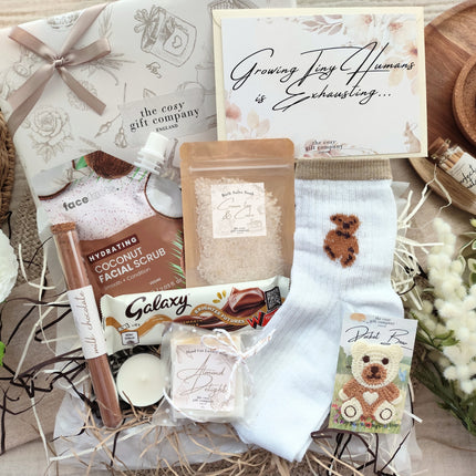 Gift Wrapped Box with various items including a bath salts, soap, and face scrub on a decorative surface with flowers.